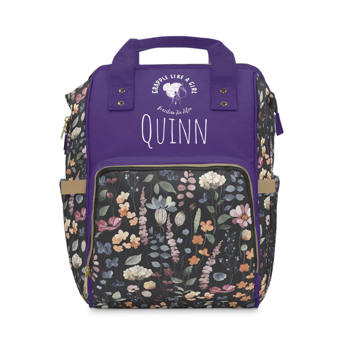 Backpack with floral pattern and purple top section, featuring the name 'Quinn'.
