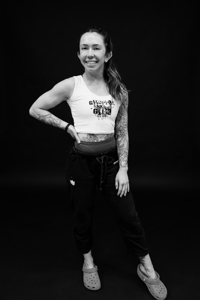 Woman wearing a Grapple Like a Girl crop top and black training pants